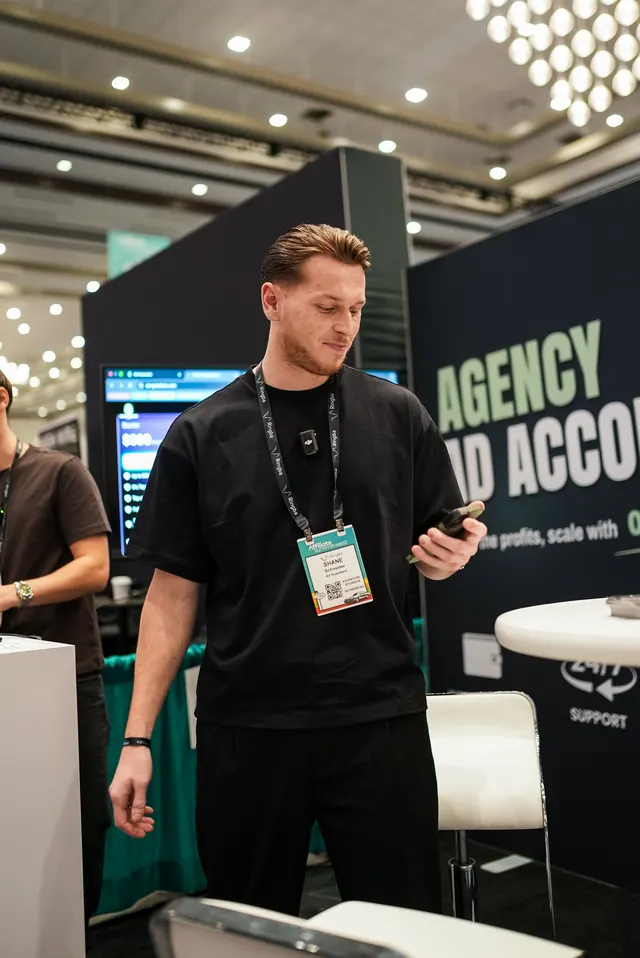 An AdGuardians team member at the booth, phone in hand